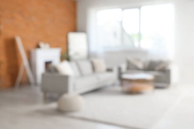 Gri koltukları, şöminesi ve kahve masası olan bulanık oturma odası manzarası.