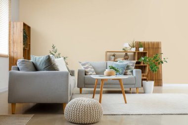 Gri kanepeleri ve masası olan oturma odasının içinde.