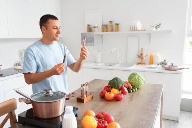 Mutfakta baharat pişiren genç bir adam.