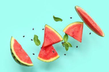 Uçan taze karpuz parçaları ve arkaplanda nane ve tohumlar.