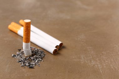 Arka planda kül olan sigaralar, yakın plan. Akciğer kanseri kavramı