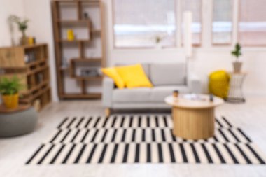 Konforlu kanepesi, raf ünitesi, ev bitkileri ve kahve masası olan, bulanık manzaralı modern oturma odası.