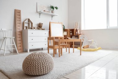 Anaokulunda oyuncakları ve beyaz tahtası olan bir oyun odası.