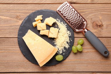Ahşap arka planda lezzetli parmesan peyniri parçaları olan tahta tahta tahta.