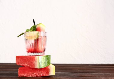 Bir bardak limonlu taze karpuz limonata ve ahşap masada nane.