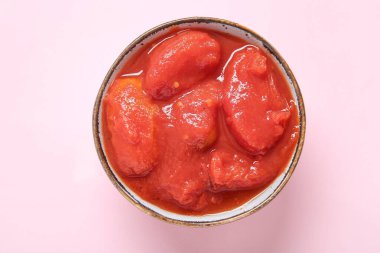 Pembe arka planda bir kase lezzetli domates.