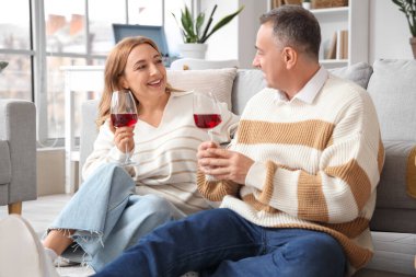 Evde şarap içen olgun bir çift.