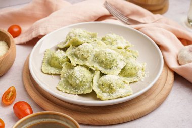 Beyaz zemin üzerinde peynir olan lezzetli bir ravioli tabağı.