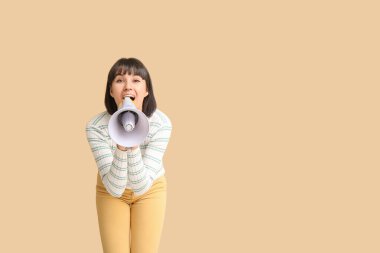 Bej arka planda megafonu olan genç bir kadın.