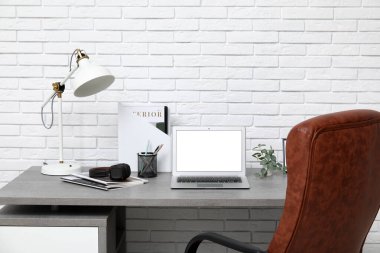 Çalışma yeri, dizüstü bilgisayarı ve koltuğu olan beyaz modern ofisin şık iç tasarımı