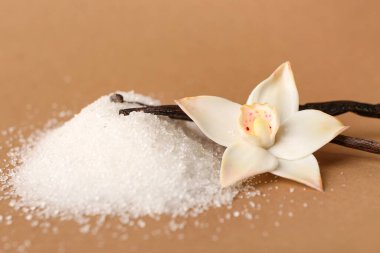 Renkli arkaplanda vanilya şekeri, çubuk ve çiçek yığını