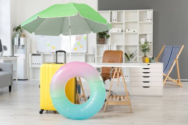 Şemsiyeli hafif ofis, bavul ve şişme yüzük. Yaz tatili kavramı