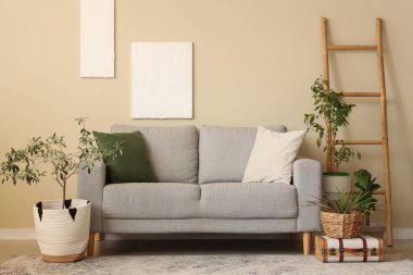 Yastıklı rahat kanepe, ev çiçekleri ve şık oturma odasında merdiven.