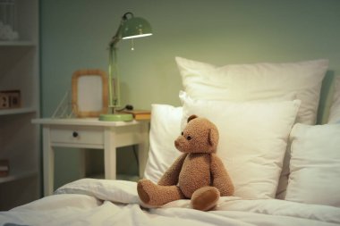 Çocukların yatak odasının içi. Geceleri rahat yatağında oyuncak ayı var.