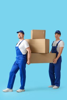 Loaders carrying cardboard boxes on blue background