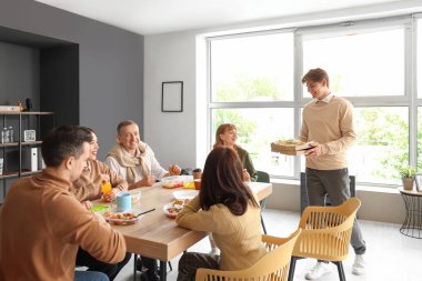 İş arkadaşları mutfakta yemek yiyor.