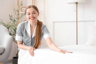 Otel odasında yatak yapma genç Oda hizmetçisi