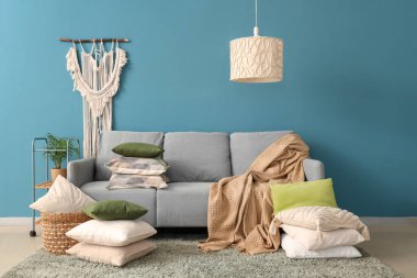 Gri kanepesi, battaniyesi ve yastıkları olan rahat bir oturma odası.