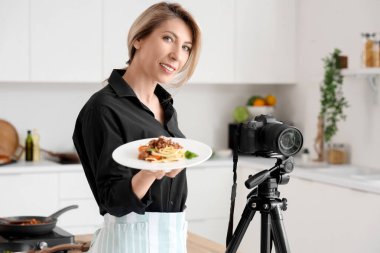 Lezzetli makarna ve kamera ile mutfakta kadın yemek blogcusu