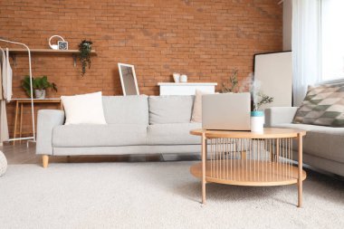 Masasında kanepeler, dizüstü bilgisayarlar ve hava nemlendiricisi olan oturma odasının içi.