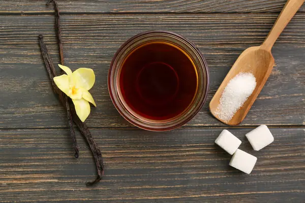 Vanilya özlü kompozisyon, sopa ve şeker koyu ahşap arka planda