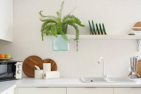 Rolls of paper towels with tissue box and cutting boards on table in kitchen
