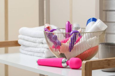 Banyoda banyo aksesuarları ve seks oyuncakları olan sepet, yakın plan.