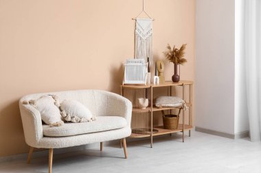 Rahat bir kanepe ve oturma odasının içinde şık dekorları olan ahşap bir raf.