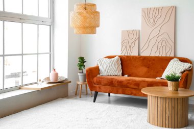 Şık bir oturma odası, rahat bir kanepe, sehpa ve resimler.