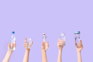 Şişeli kadın elleri ve arkaplanda bir bardak su.