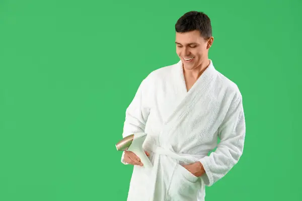 stock image Young man with photoepilator on green background