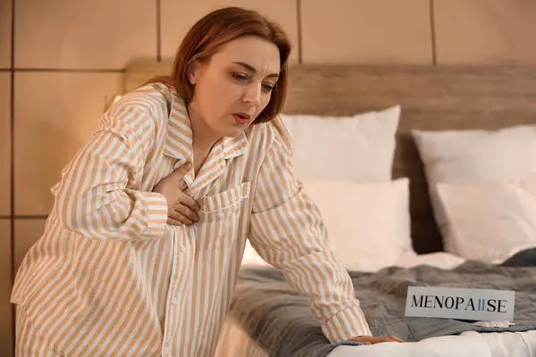 stock image Mature woman experiencing menopause in bedroom at night
