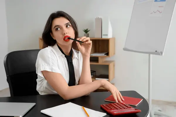stock image Sexy secretary with pen sitting at table in office