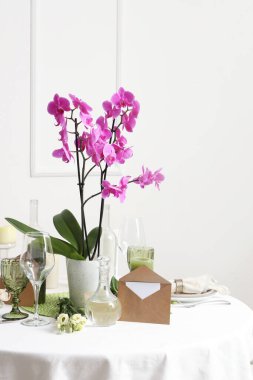 Orkide çiçekli güzel bir masa. Düğün kutlaması için aydınlık duvarın yanında.
