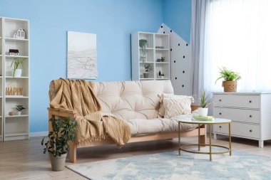 Oturma odasının iç tarafında ekoseli ve kahve masalı bir kanepe.