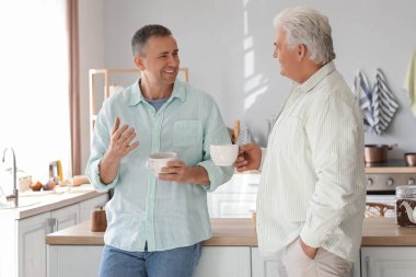 Olgun kardeşler mutfakta çay içiyor.