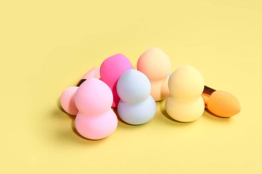 Sarı arkaplanda farklı makyaj süngerleri