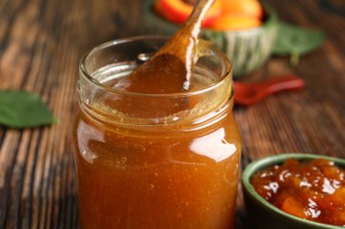 Kavanoz ve kayısı reçeli ahşap masada.