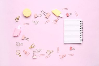 Pembe arka planda farklı kırtasiye malzemesi içeren defterden yapılmış çerçeve