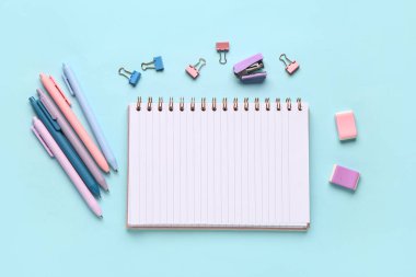 Mavi arkaplanda farklı kırtasiye malzemesi olan defter