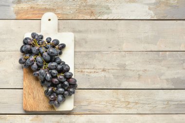 Gri ahşap arka planda tatlı siyah üzümlü tahta.