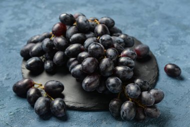 Mavi arka planda tatlı siyah üzümlü tahta