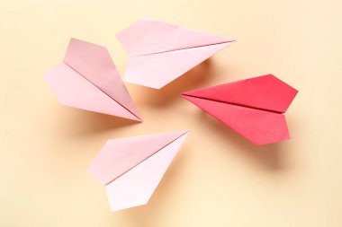 Bej arkaplanda renkli origami kağıt uçaklar