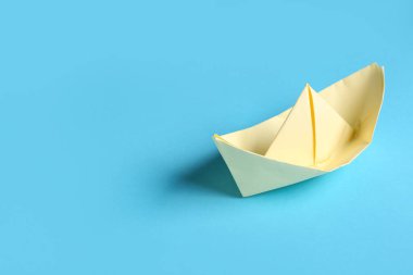 Mavi arkaplanda sarı origami teknesi