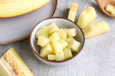 Beyaz arka planda tatlı kavun parçaları olan kase