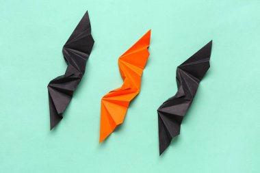 Turkuaz arka planda farklı origami yarasaları