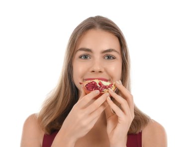 Beyaz arka planda nar yiyen genç kadın, yakın plan.