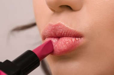 Renk arkaplanına güzel ruj süren kadın, yakın plan