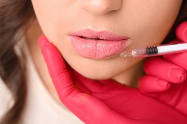 Güzel kadın dudak iğnesi yaptırıyor, yakın plan.