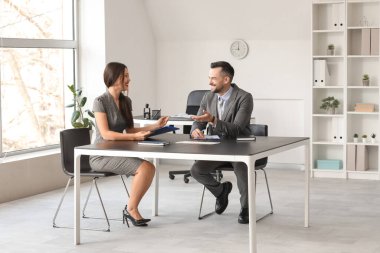 İnsan Kaynakları Müdürü, kadın başvuru sahibini ofisinde sorguluyor.